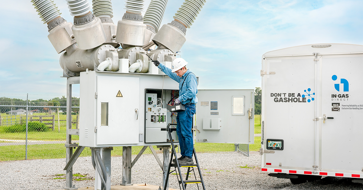 In-Gas Direct field technician using a handheld detector to check for SF₆ gas leaks at an electrical substation.